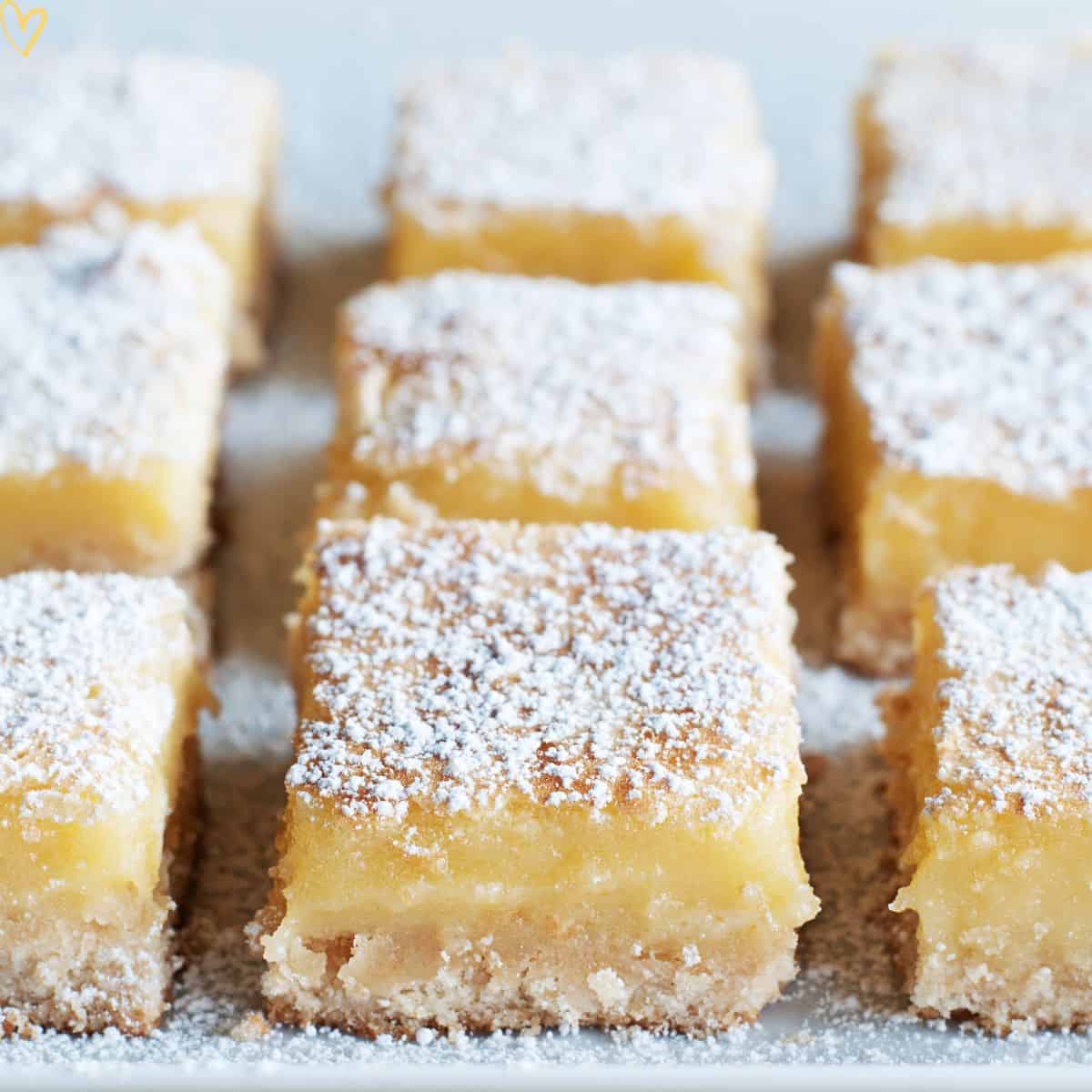Healthy lemon bars with powdered sugar cut into squares on a tray