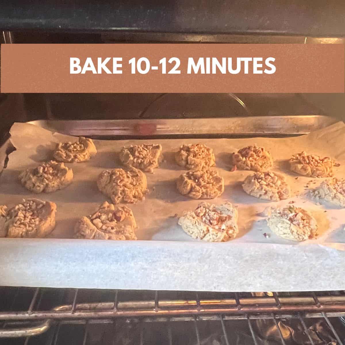 Almond Flour Butter Cookies baking on a parchment-lined baking sheet in the oven until lightly golden.