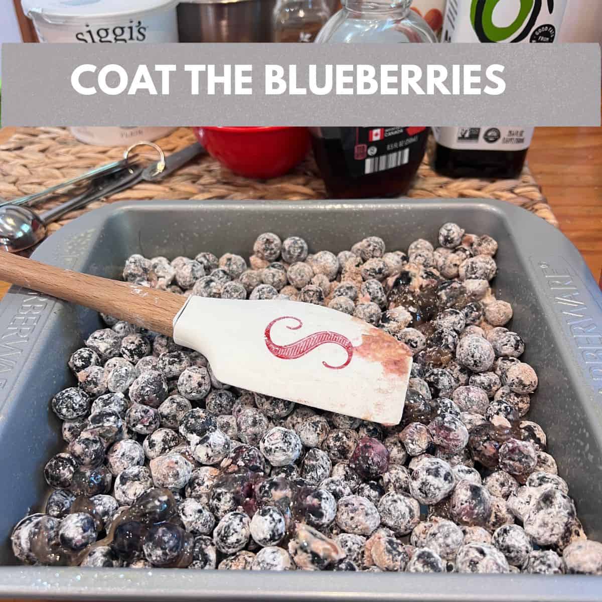 Blueberries coated with cornstarch, maple syrup, vanilla extract, and cinnamon in an 8x8-inch baking dish before baking an Easy 5-Ingredient Shortcut Blueberry Cobbler.