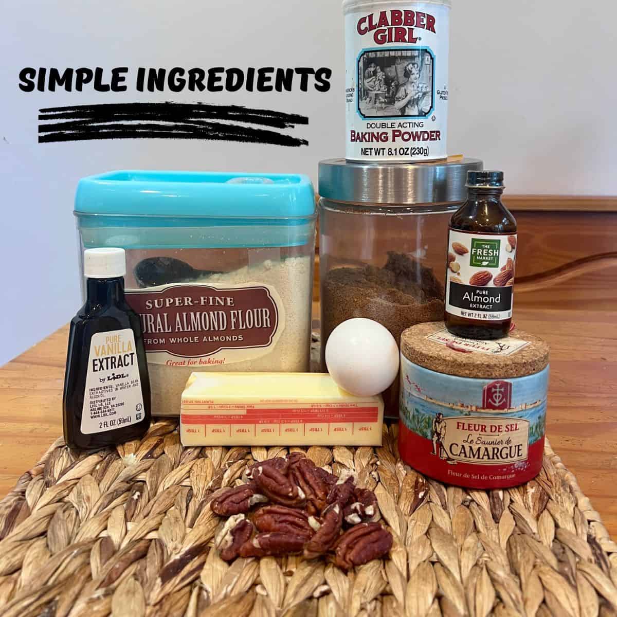 Ingredients for Almond Flour Butter Cookies including almond flour, coconut sugar, egg, baking powder, vanilla extract, and almond extract arranged on a table before baking.