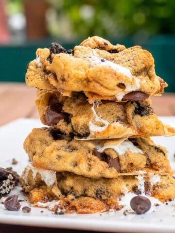 Stack of gooey Oreo marshmallow chocolate chip cookies with melted marshmallows, chocolate chips, and crushed Oreo pieces.