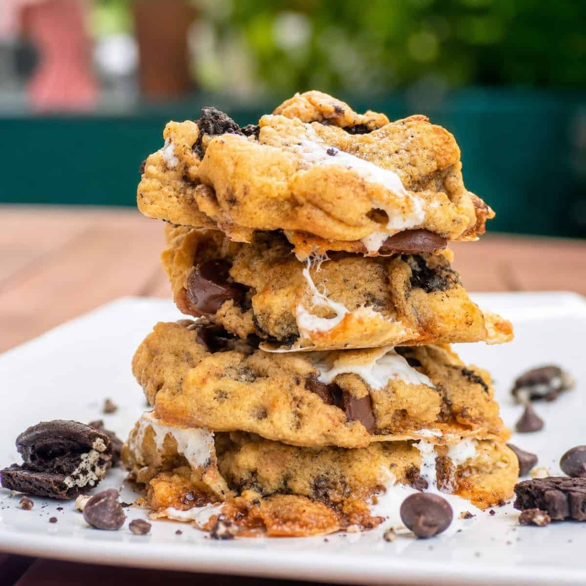 Stack of gooey Oreo marshmallow chocolate chip cookies with melted marshmallows, chocolate chips, and crushed Oreo pieces.