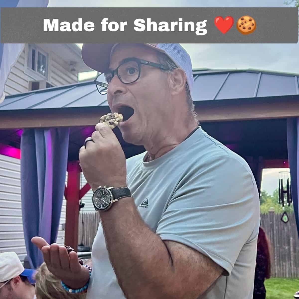 Man enjoying an Oreo chocolate chip marshmallow cookie at an outdoor family gathering