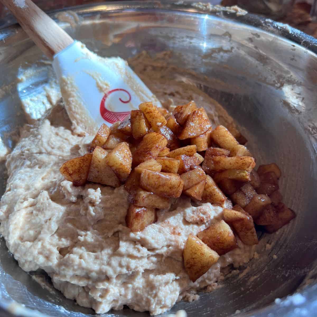 Thick healthy apple fritter muffin batter with cinnamon apples folded in