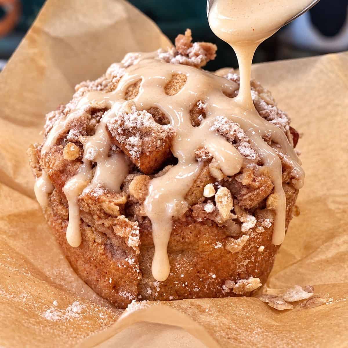 Healthy apple fritter muffin with maple glaze drizzled over cinnamon apple streusel