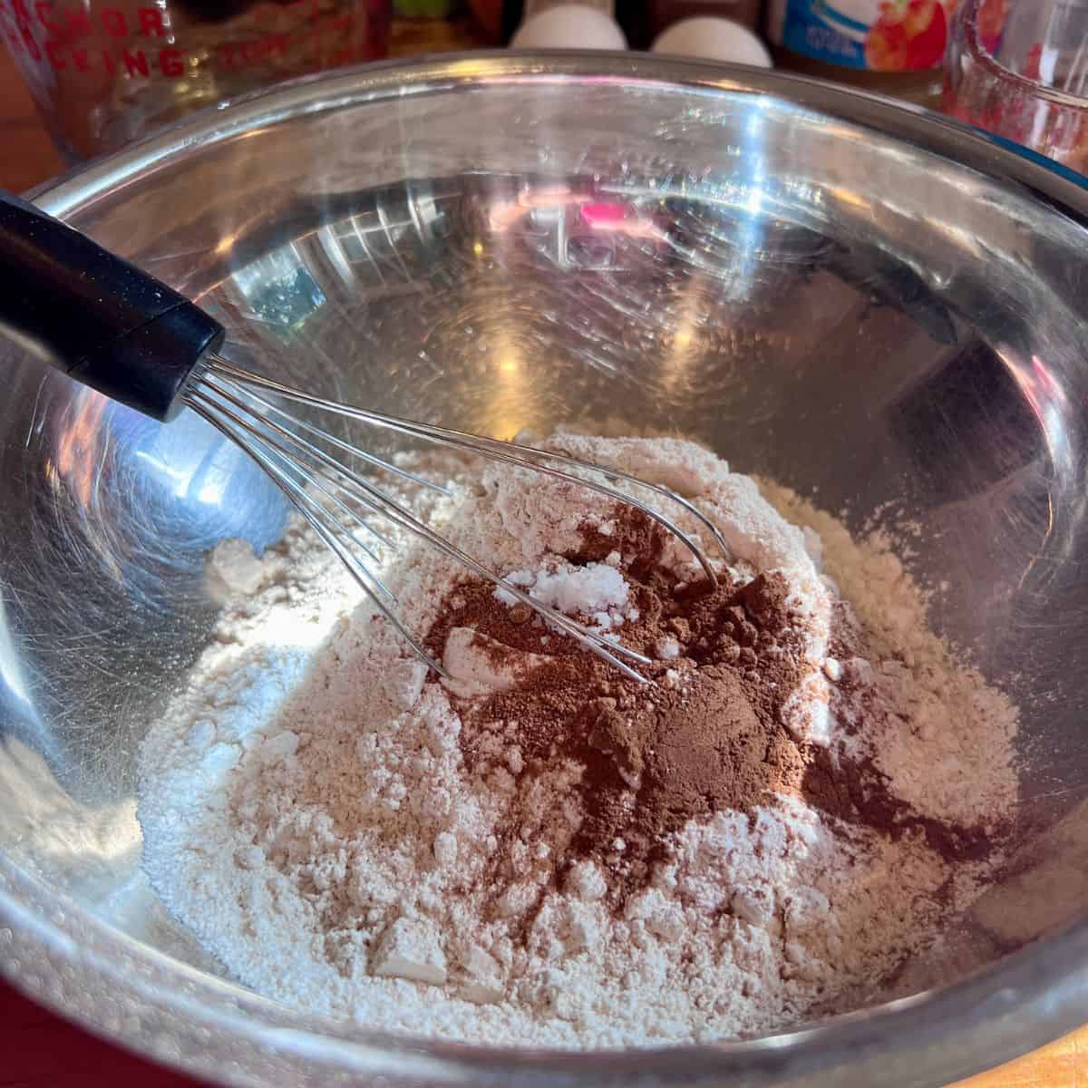 Dry ingredients for apple fritter muffins being mixed with a whisk