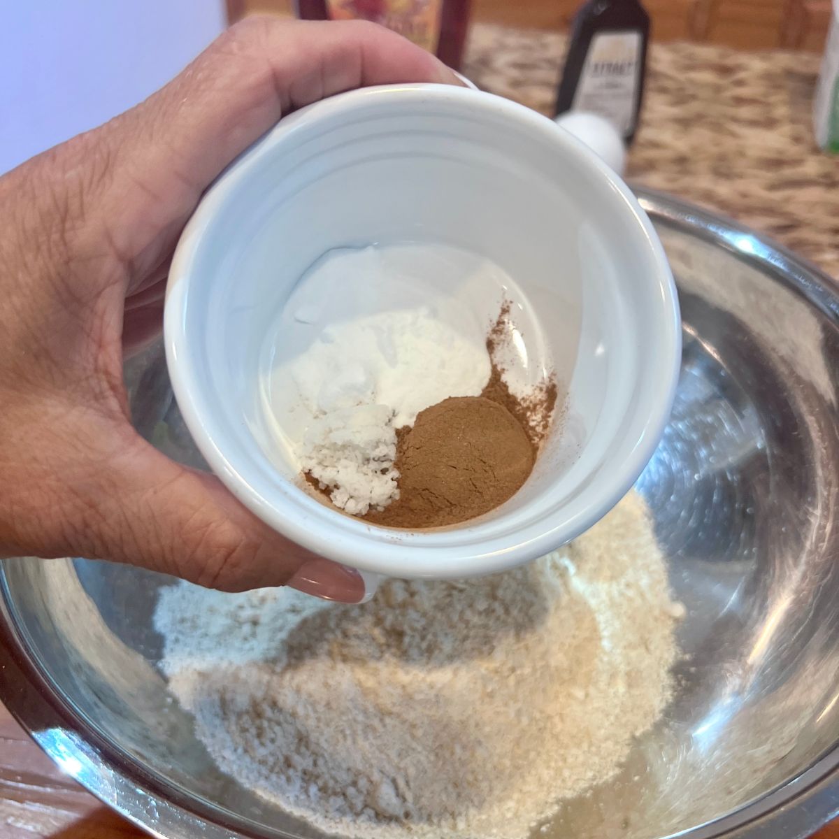 Salt, cinnamon and baking soda being added to oat flour for pumpkin sweet potato muffins
