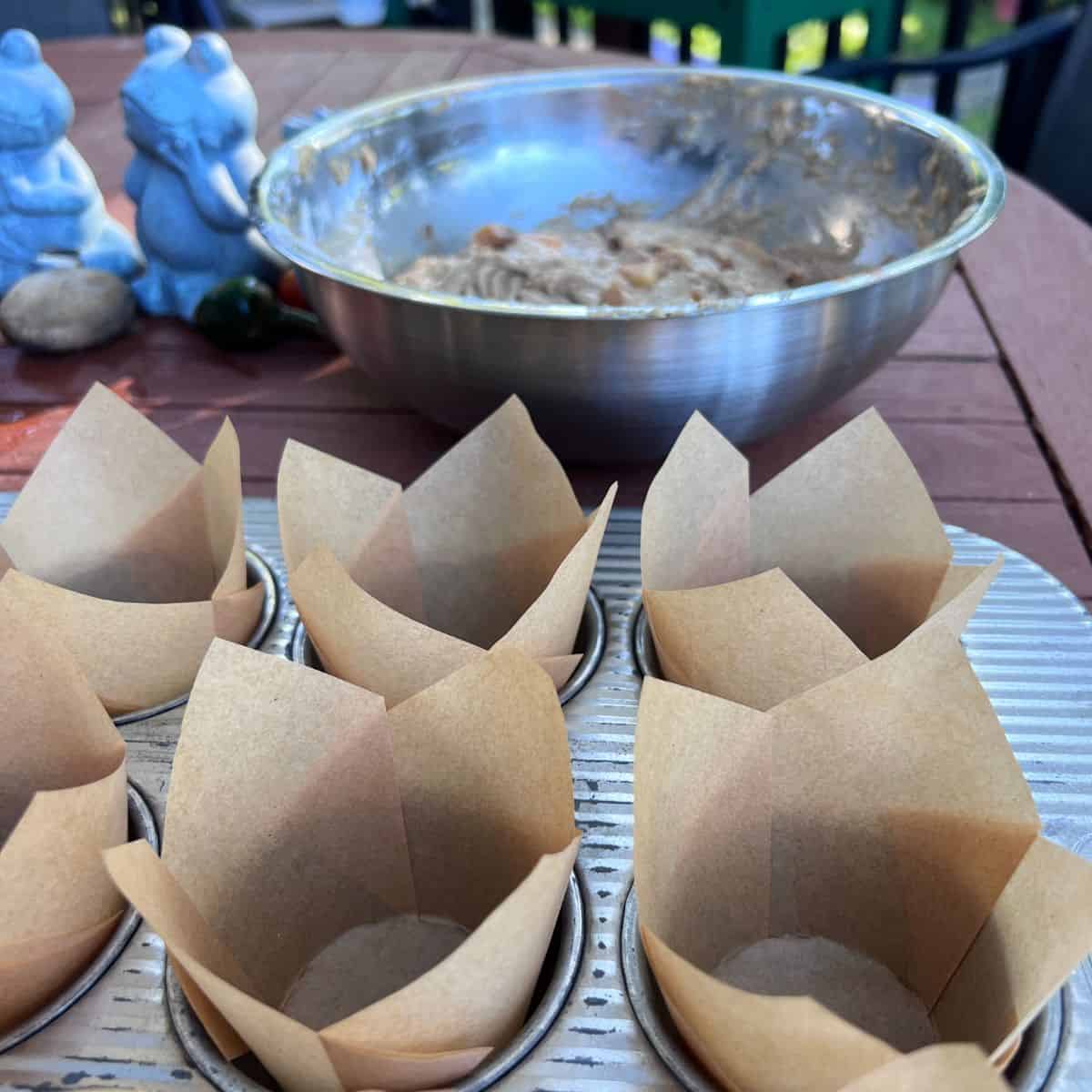 Standard muffin pan lined with parchment paper liners for healthy apple fritter muffins
