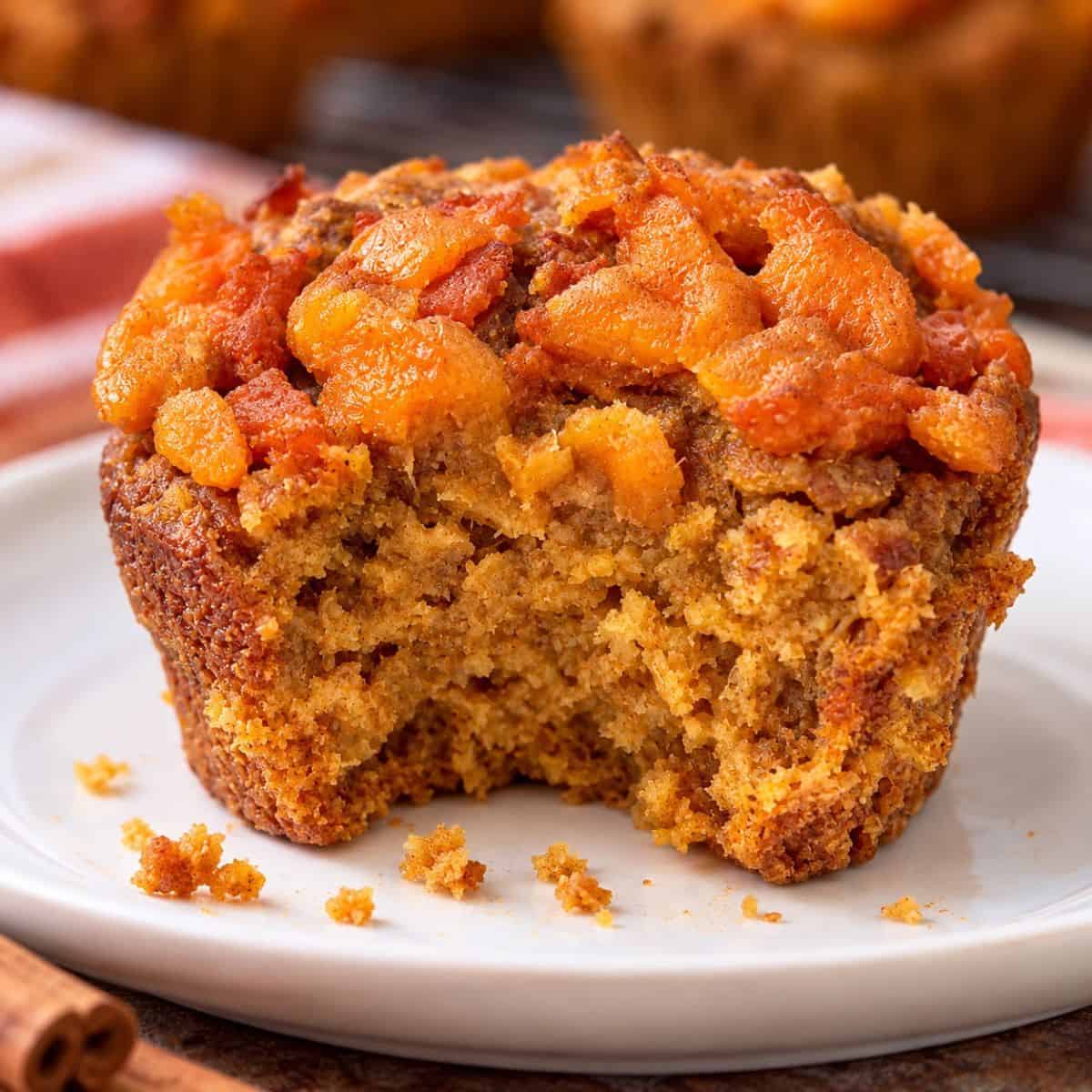 Pumpkin sweet potato muffin with a bite taken out showing the moist inside texture