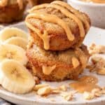 Two stacked 3-ingredient peanut butter banana mini muffins topped with creamy peanut butter drizzle.